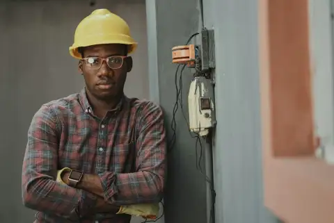 A civil engineer in a yellow hard hat at a building site